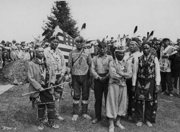 Posed photograph of seven Native American men at Chief Kaquados's reinterment ceremony.
