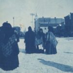 Polish immigrant women at the Market Square wearing traditional, national clothing. In the background are brick buildings. A sign on one building reads: "Curran and Wiesner. Kentucky Liquor Store. Bankers, Pawnbrokers."