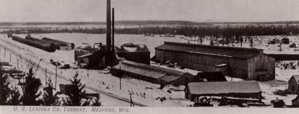 Elevated view of an early-twentieth century industrial complex. Caption reads: "U.S. Leather Co. Tannery, Medford, Wis."