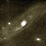 Image of a star nebula, a bright star at the center of a spiral nebula.