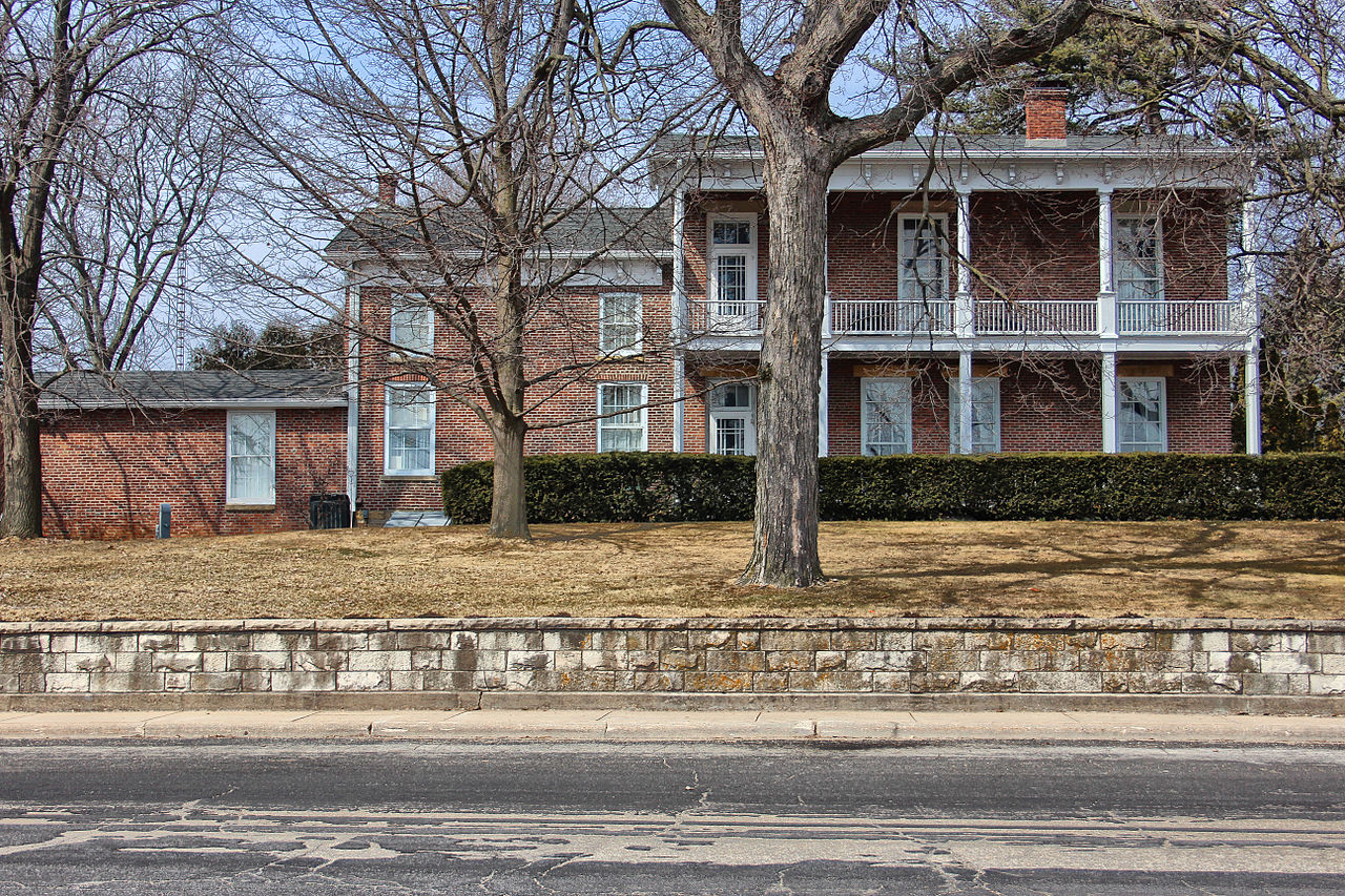 A photo of the Rountree Mansion in Platteville, a two-story brick house with full span, two-level porch.