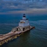 Photograph of the Manitowoc Breakwater Lighthouse from the harbor. The lighthouse is located on the end of the rocky breakwater and extends into Lake Michigan.