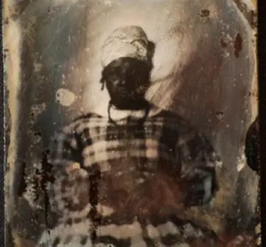 An ambrotype of America Jenkins in plaid dress and tignon headscarf.