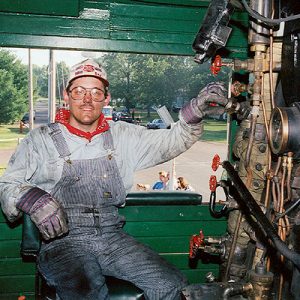 Color photograph of an engineer inside Soo Line 1003's engine