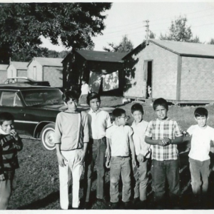 The author and other children from Bond Village. Cabins such as the one profiled here can be seen in the background behind the children. Image courtesy of the author.