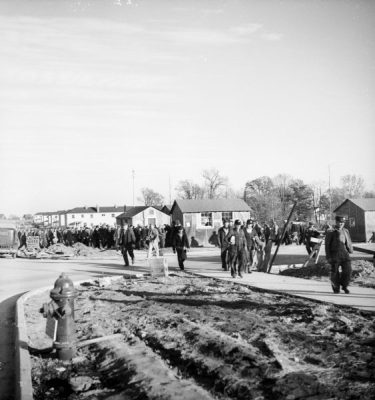 Construction workers walking through the Greendale neighborhood, circa 1937. Photograph by Raymond J. Miller, from the Wisconsin Historical Society, image #63738.