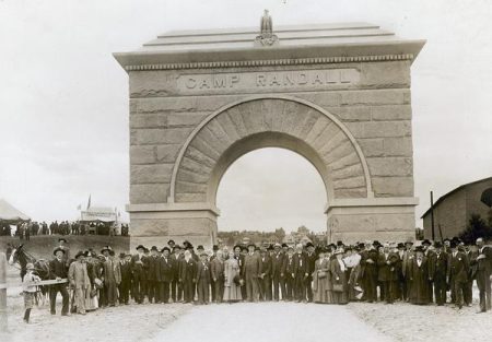 A group poses in front of the newly built Camp Randall Arch during its dedication to the Civil War veterans trained at Camp Randall. Wisconsin Historical Society ID: 11270.