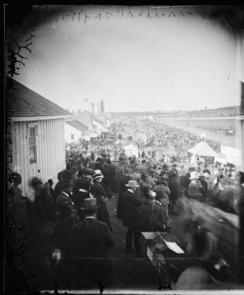 A crowd watches the horse race at the Wisconsin State Fair, held at Camp Randalll fairgrounds. September 10, 1879. Wisconsin Historical Society ID: 27335.