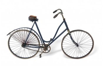 A blue bicycle with low sweeping top pipe and spoked chain guards around the rear wheel.