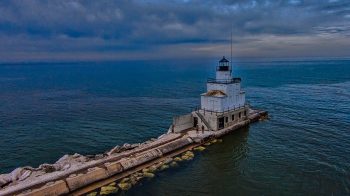 Photograph of the Manitowoc Breakwater Lighthouse from the harbor. The lighthouse is located on the end of the rocky breakwater and extends into Lake Michigan.