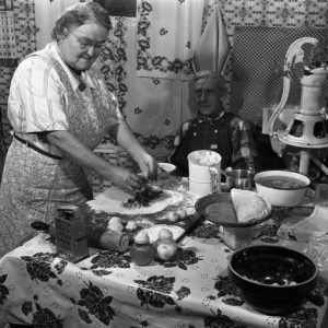 A woman making pasties in a black and white photo