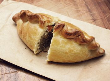 an image of a cut cornish pasty showing the filling and edging